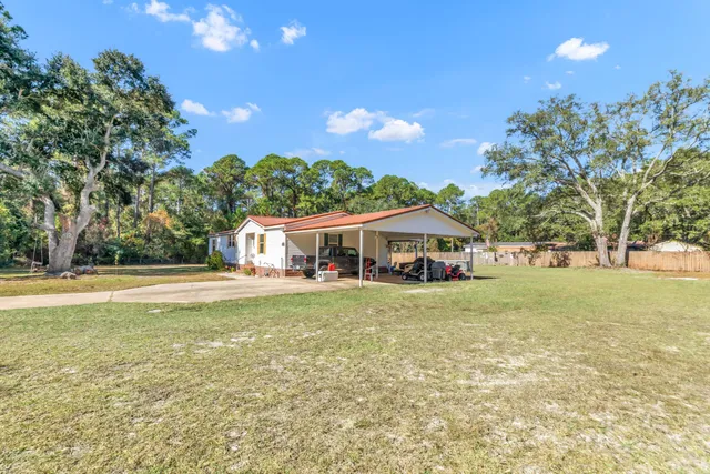 a view of a house with a patio and a yard