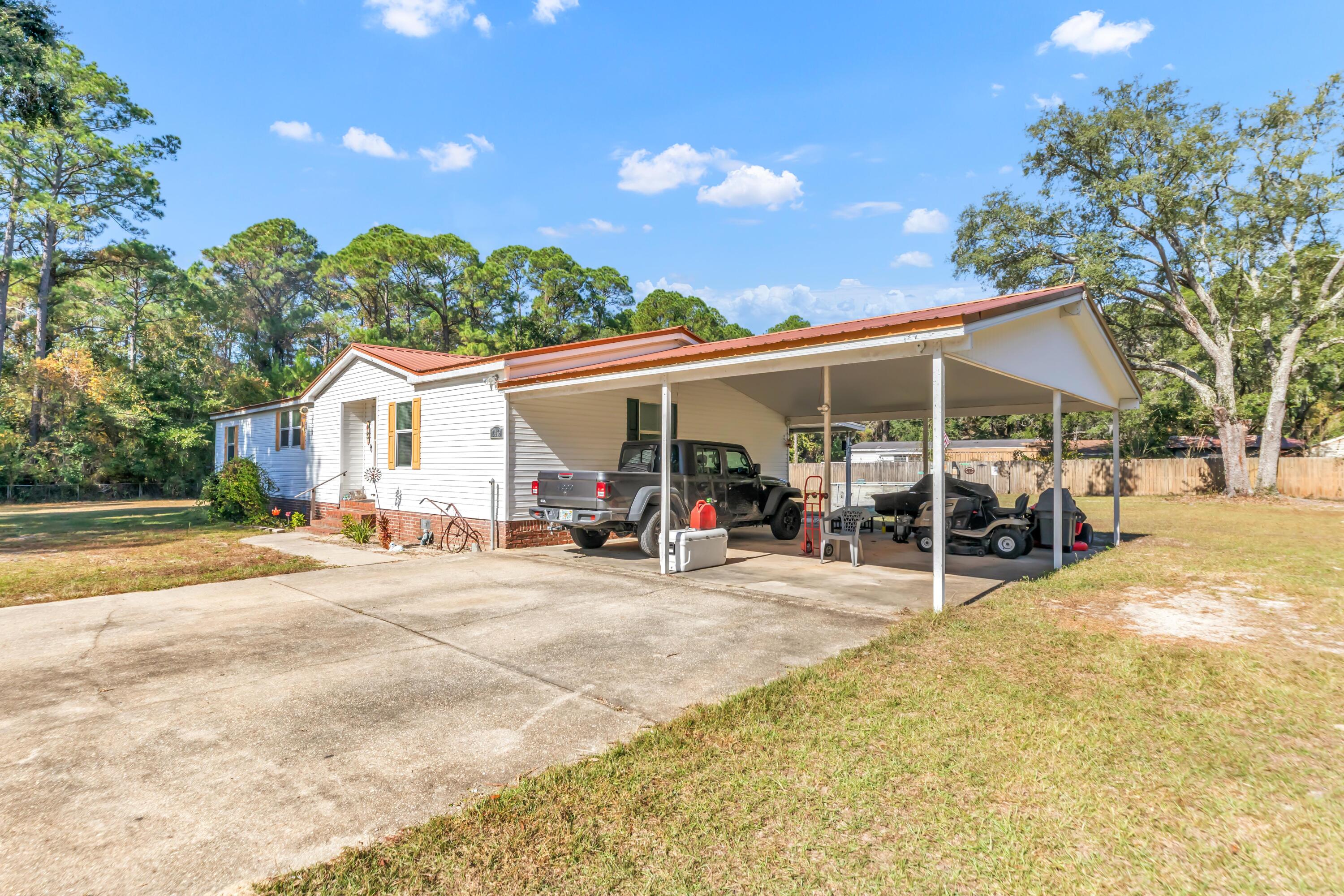 7478 Rose Street Navarre, FL 32566 - Photo 12 of 60 a view of a house with a patio and a yard