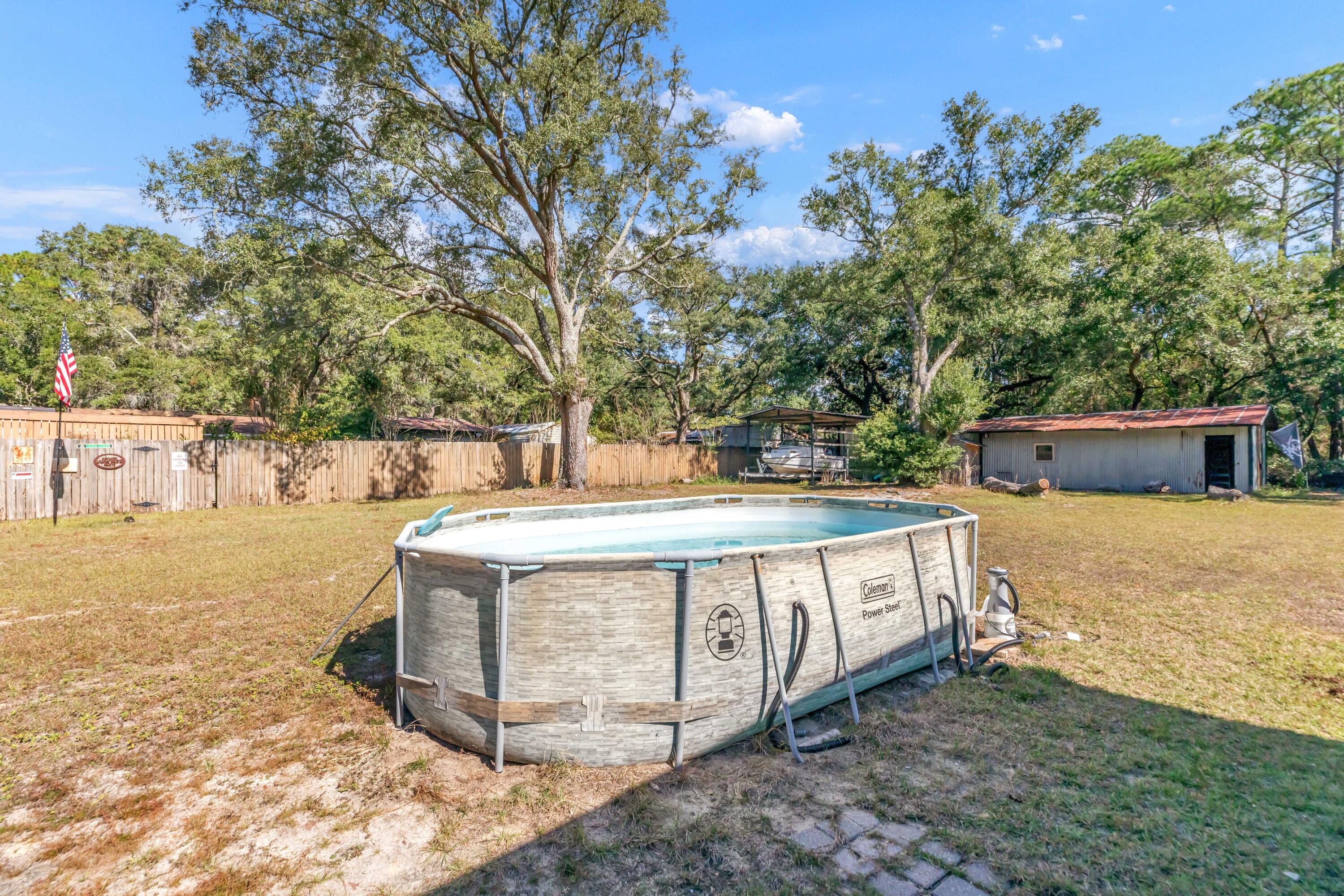 7478 Rose Street Navarre, FL 32566 - Photo 17 of 60 a view of a backyard with trees