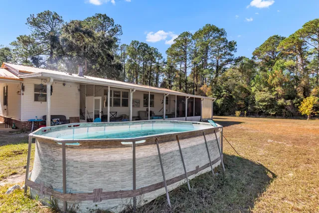 a view of a house with backyard and sitting area