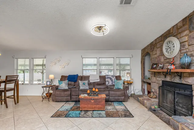 a living room with furniture a fireplace and a large window