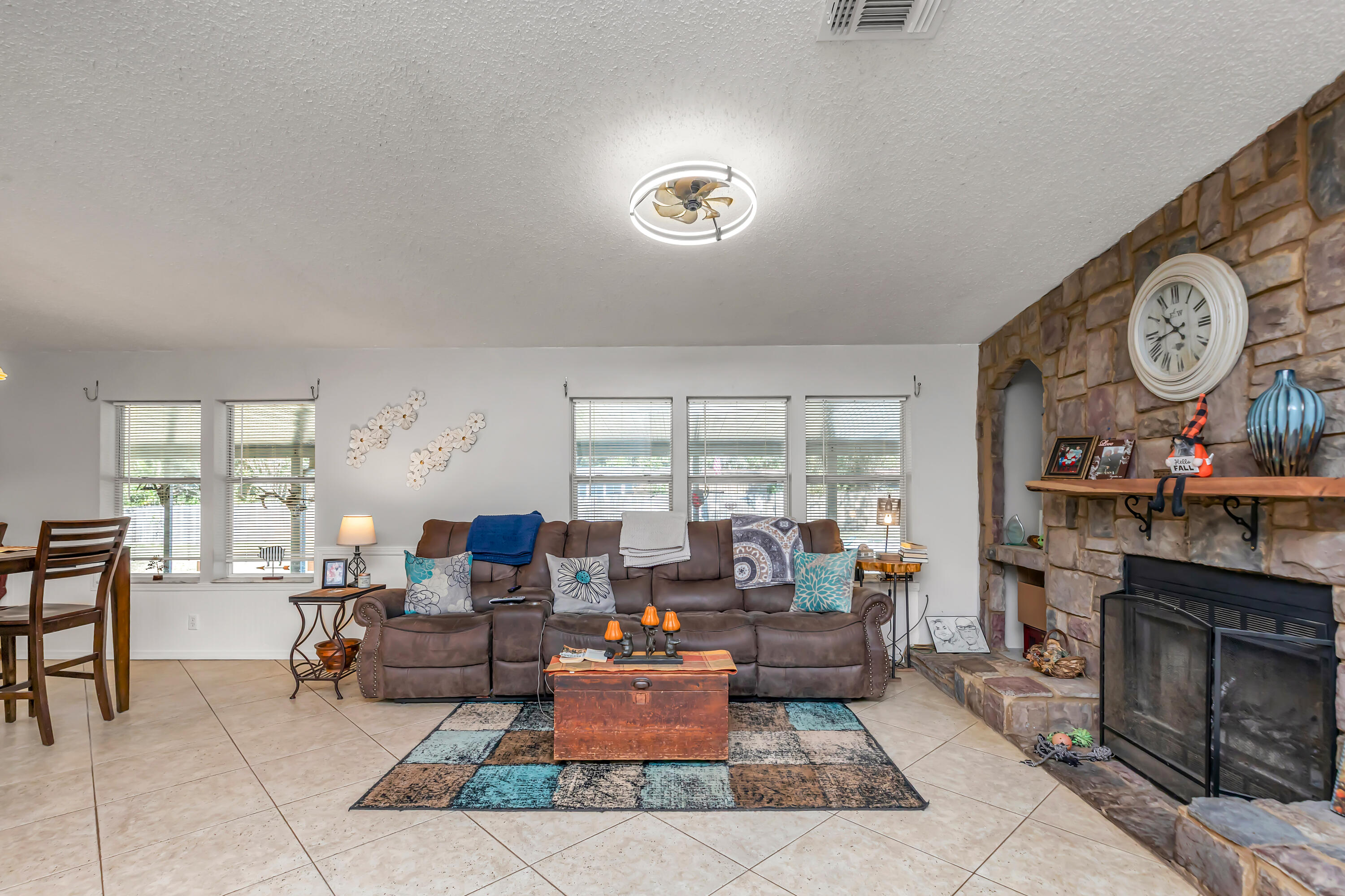 7478 Rose Street Navarre, FL 32566 - Photo 21 of 60 a living room with furniture a fireplace and a large window