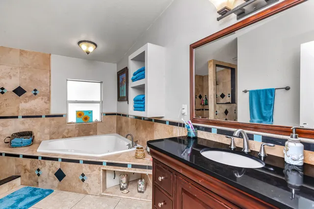 a bathroom with a granite countertop sink and a mirror