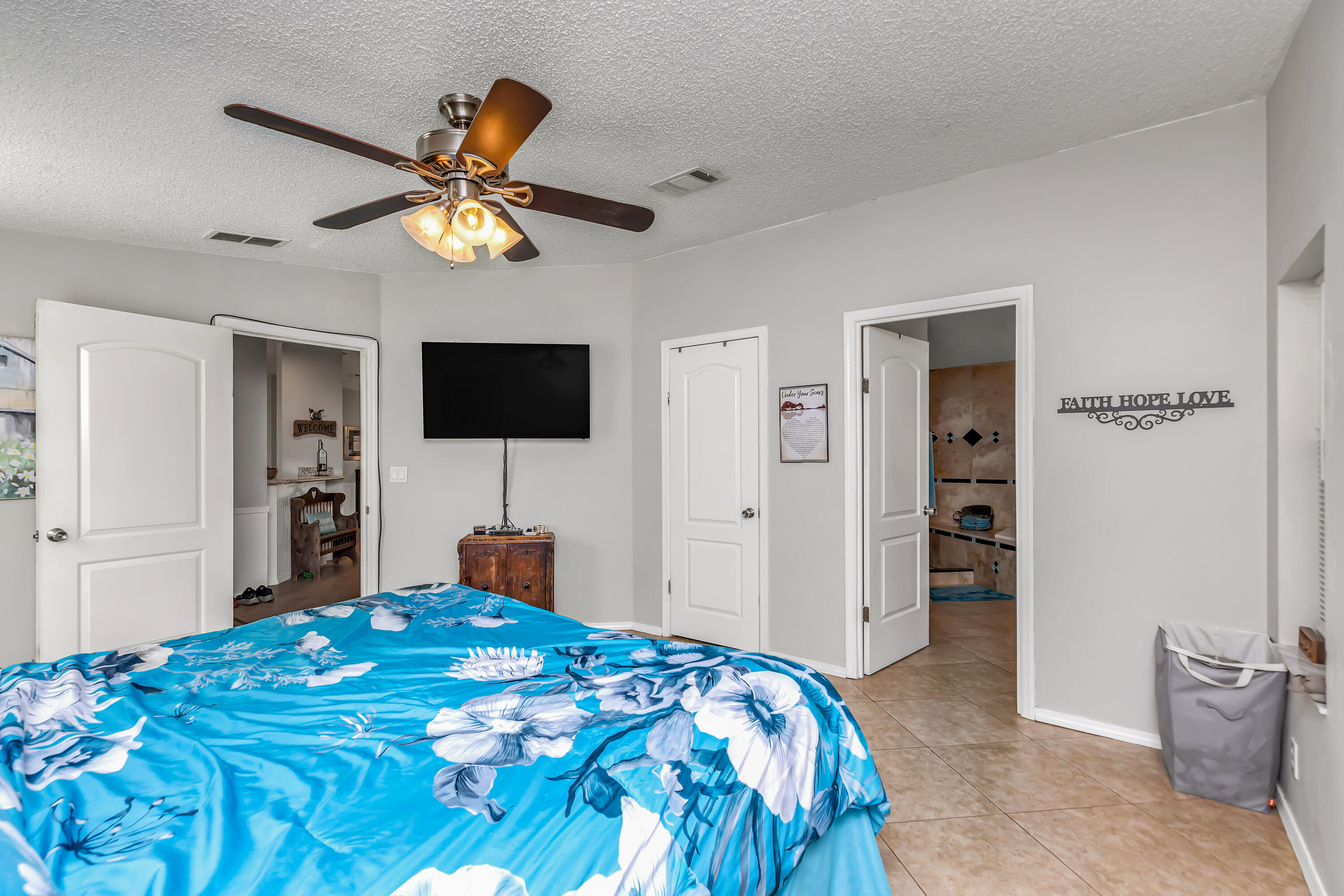 7478 Rose Street Navarre, FL 32566 - Photo 31 of 60 a bedroom with a bed and a flat tv screen on dresser