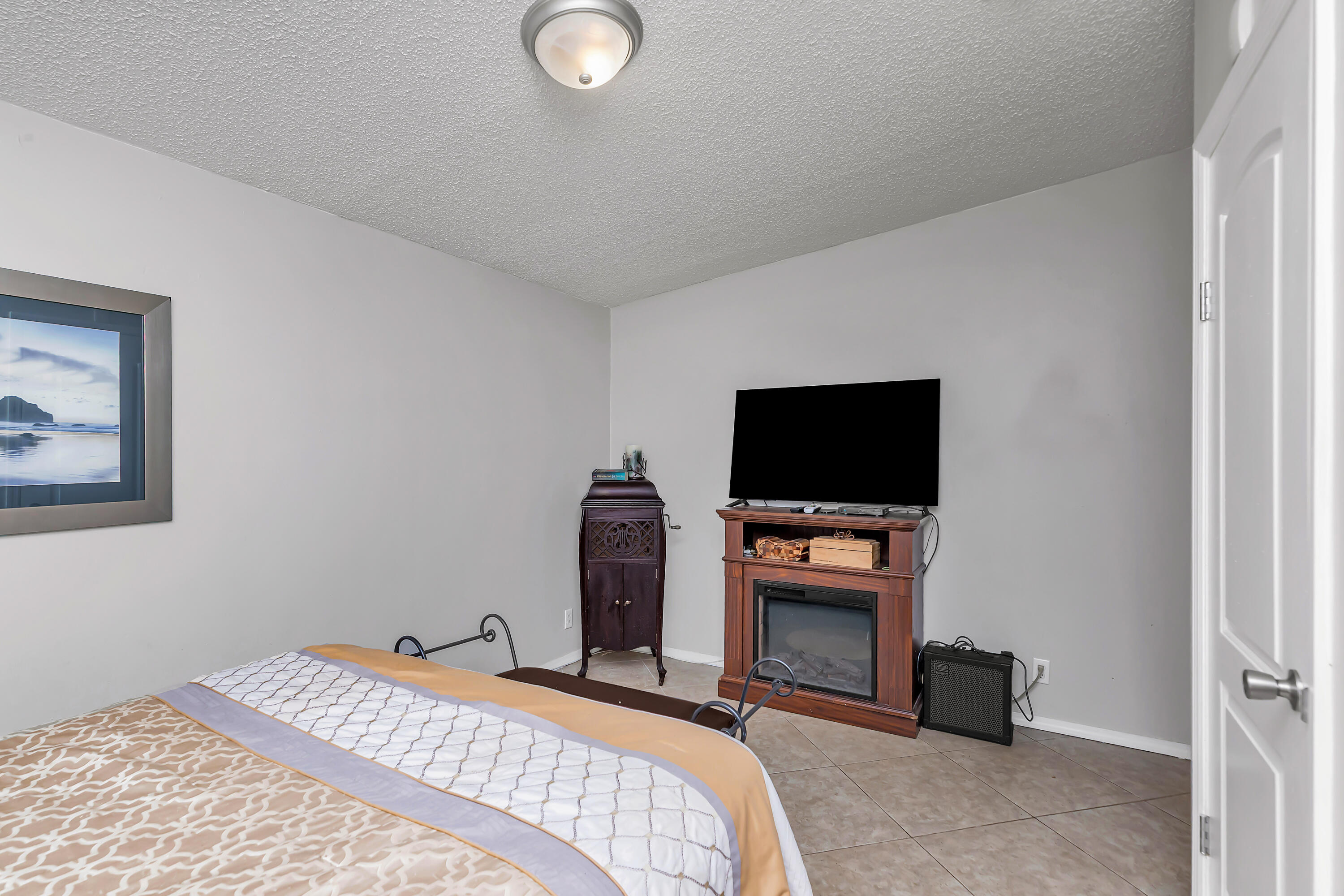 7478 Rose Street Navarre, FL 32566 - Photo 36 of 60 a bedroom with a bed and a flat screen tv