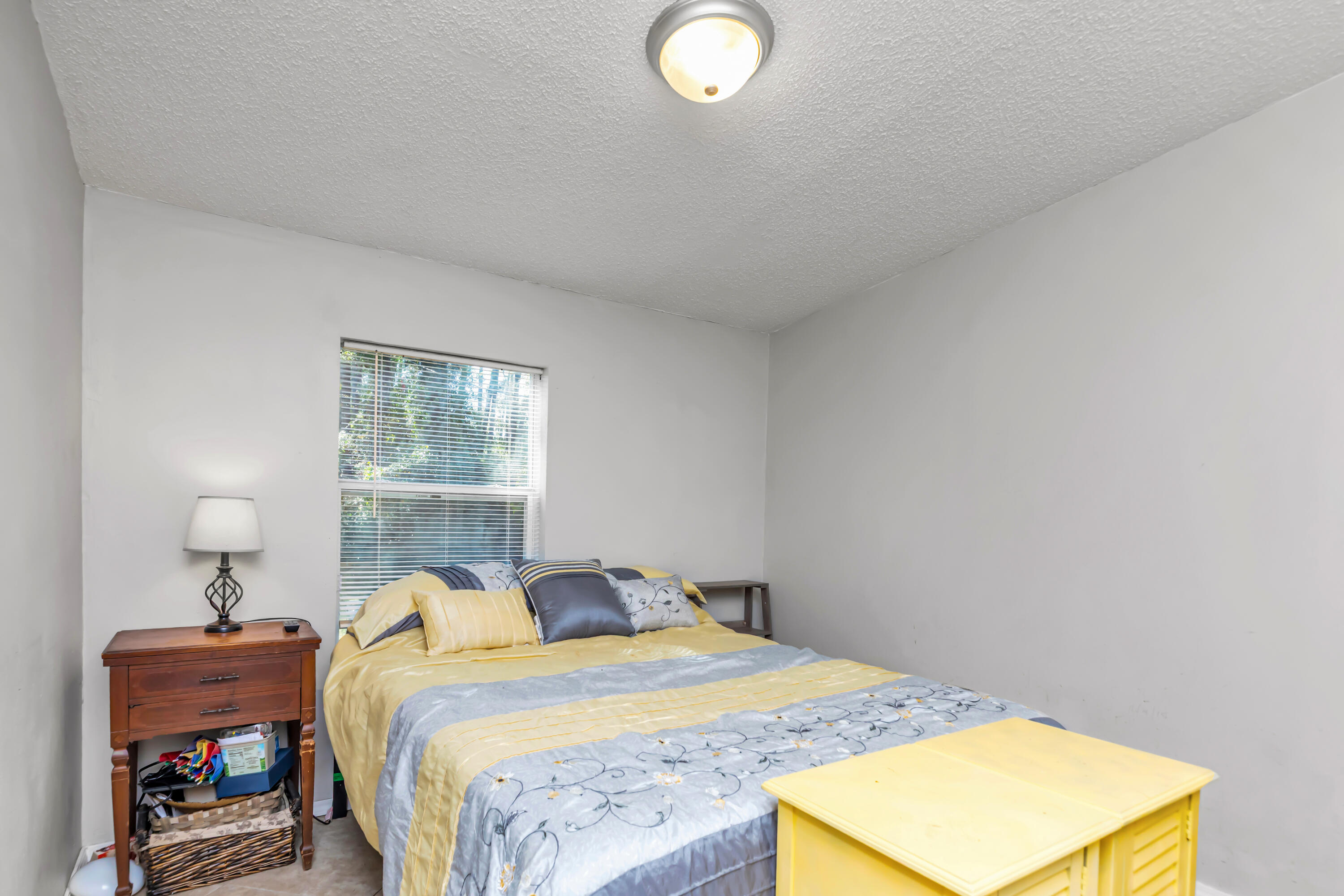 7478 Rose Street Navarre, FL 32566 - Photo 39 of 60 a bedroom with a bed and a lamp on dresser