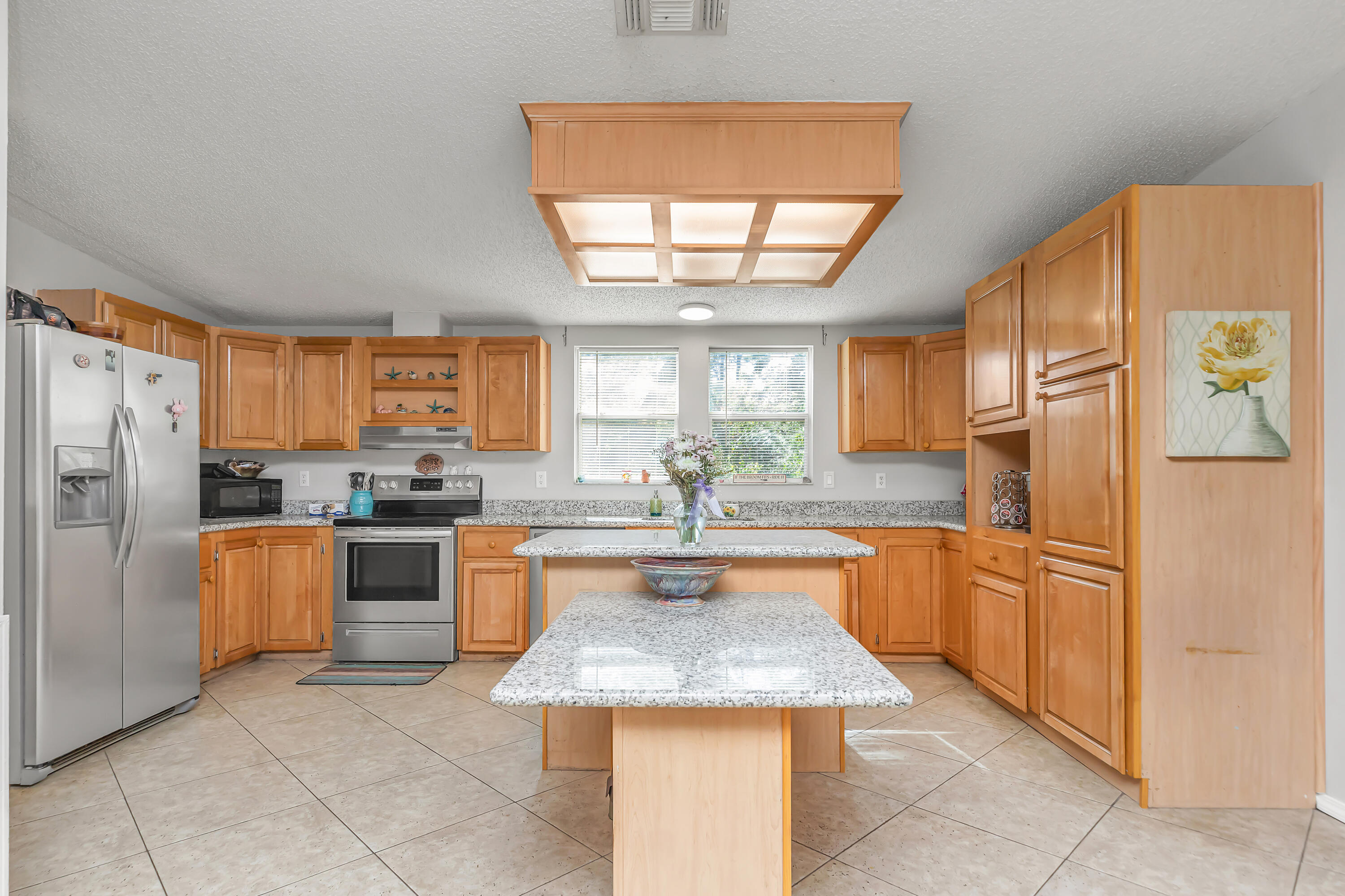 7478 Rose Street Navarre, FL 32566 - Photo 4 of 60 a kitchen with stainless steel appliances granite countertop a refrigerator a sink dishwasher a oven with a dining table and chairs with wooden floor