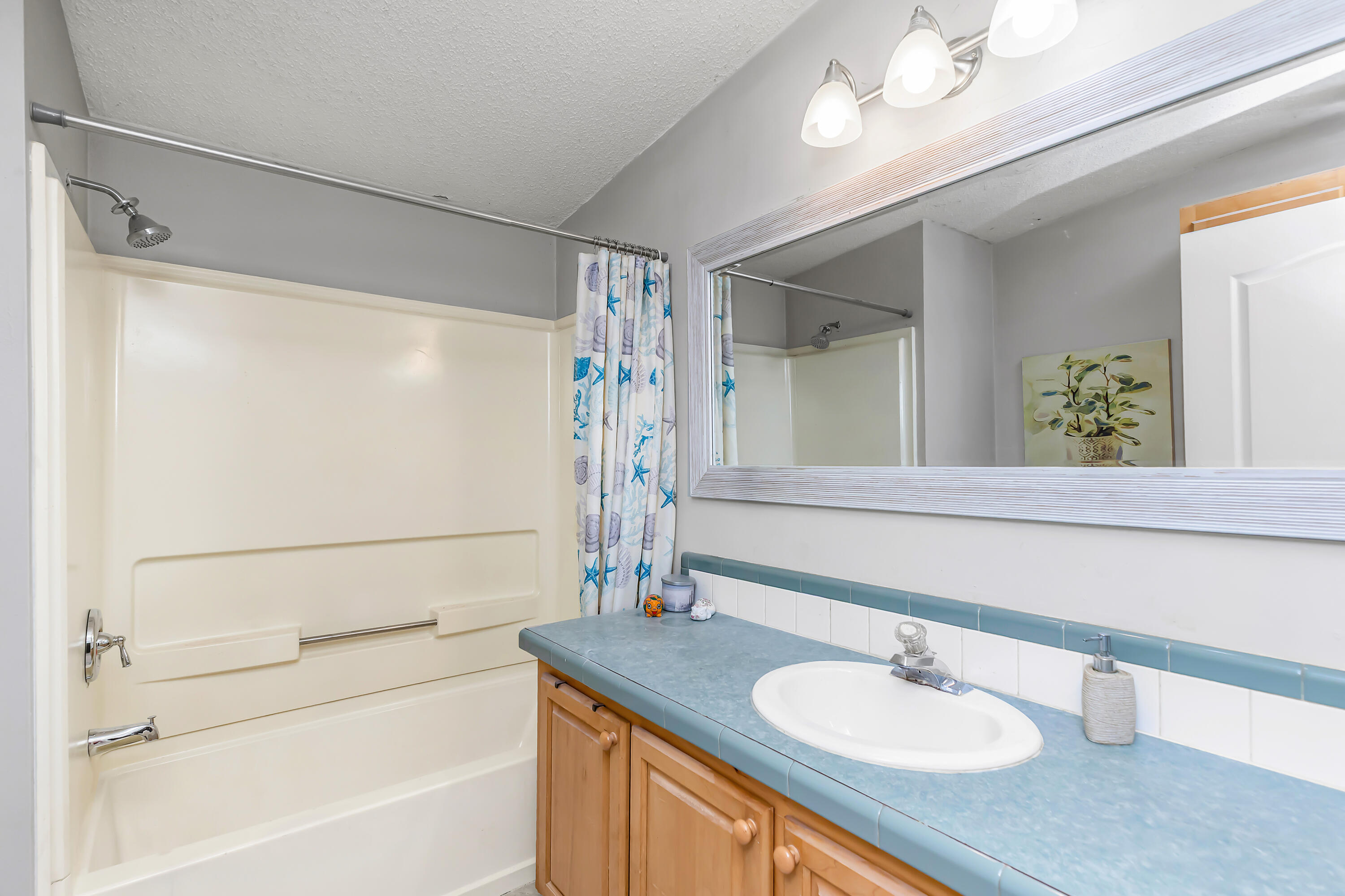 7478 Rose Street Navarre, FL 32566 - Photo 42 of 60 a bathroom with a sink vanity granite tub shower and a mirror