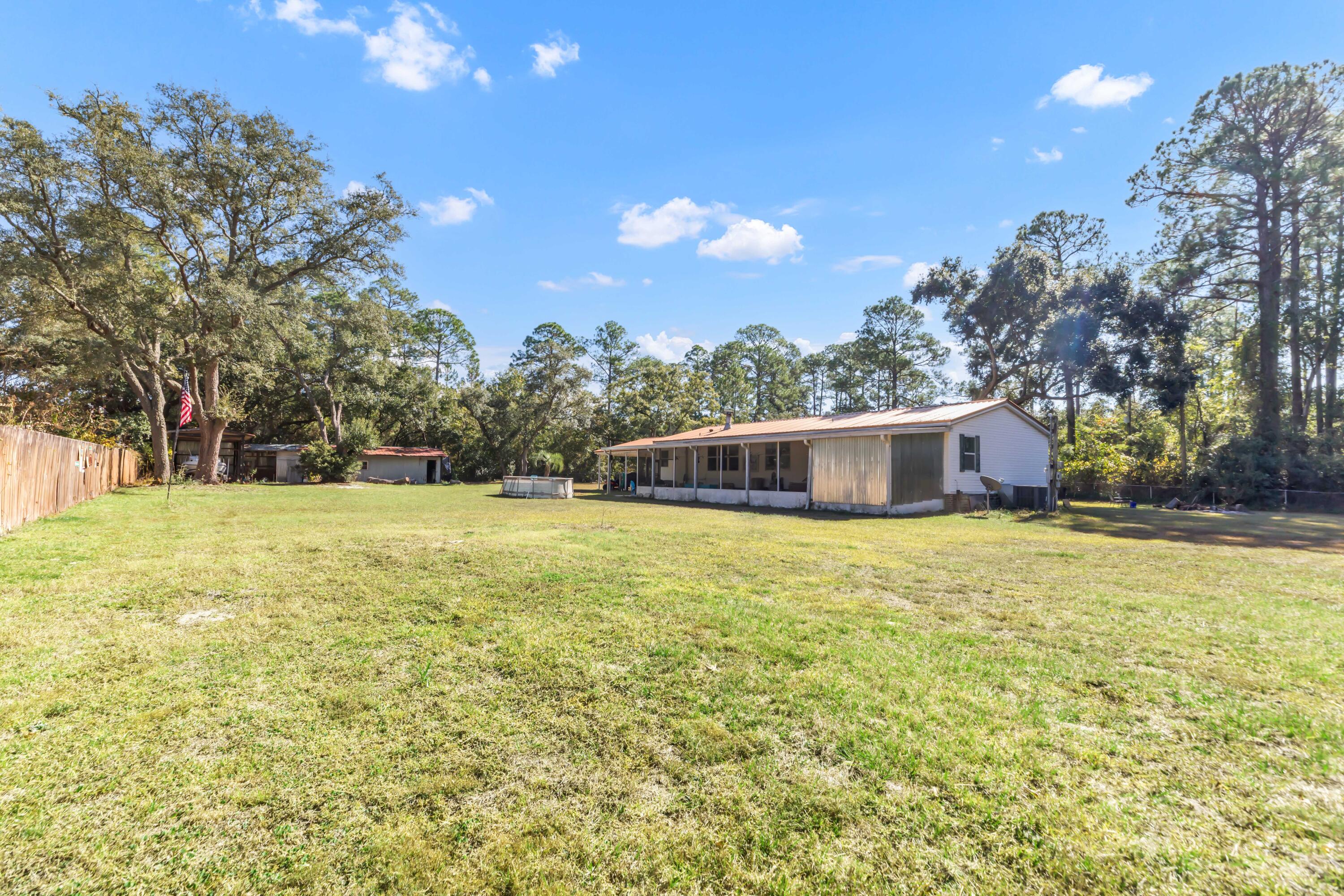 7478 Rose Street Navarre, FL 32566 - Photo 47 of 60 a front view of house with yard and trees in the background