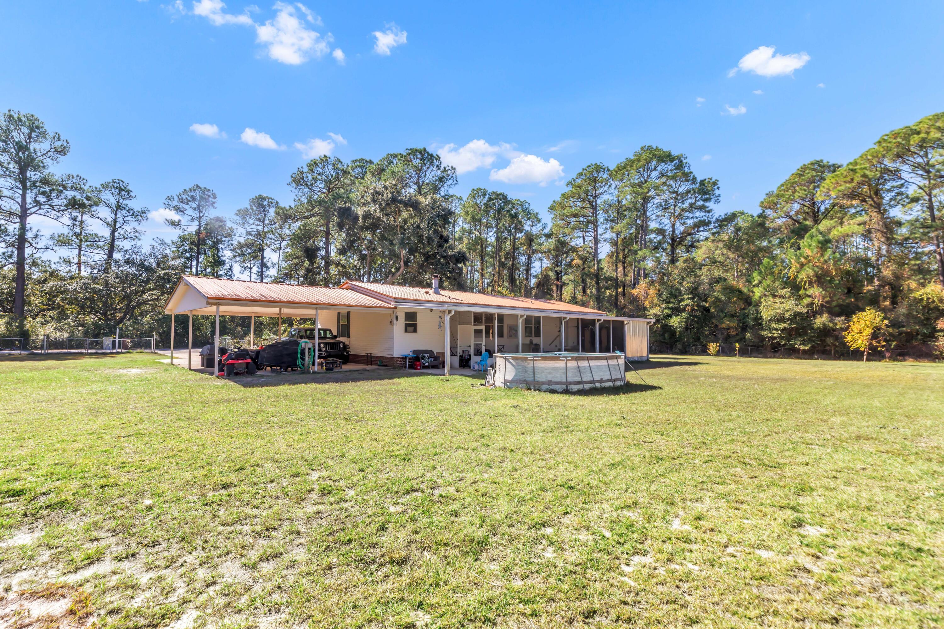7478 Rose Street Navarre, FL 32566 - Photo 49 of 60 a view of a house with yard and sitting area