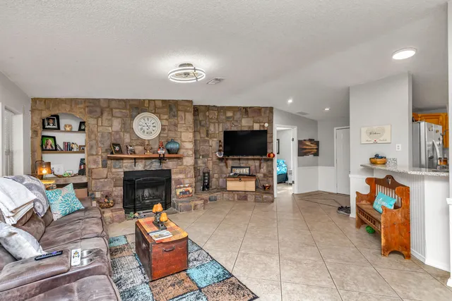 a living room with furniture a flat screen tv and a fireplace