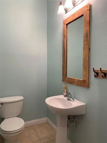 a bathroom with a sink a toilet and mirror