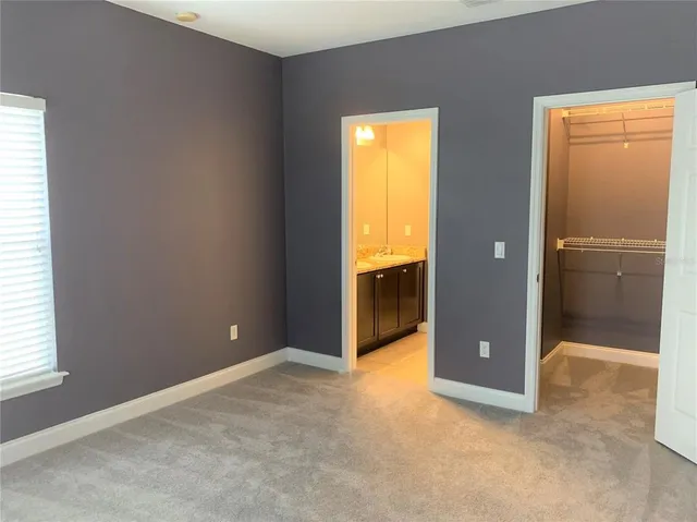 an empty room with a bathroom and a window