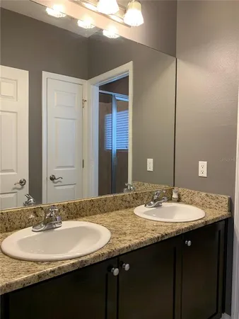a bathroom with a double vanity sink and a mirror