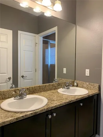 a bathroom with a double vanity sink and a mirror