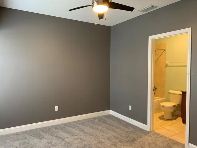 an empty room with a lamp and a chandelier fan