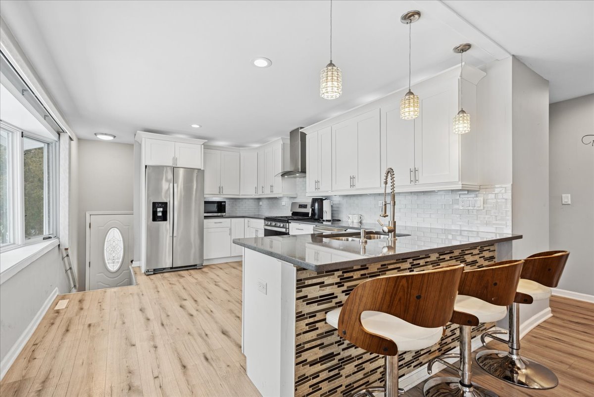 128 McCabe Drive Streamwood, IL 60107 - Photo 6 of 19 a kitchen with stainless steel appliances granite countertop a stove a sink dishwasher and a refrigerator with wooden floor