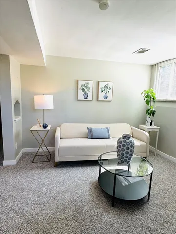 a living room with furniture and a potted plant