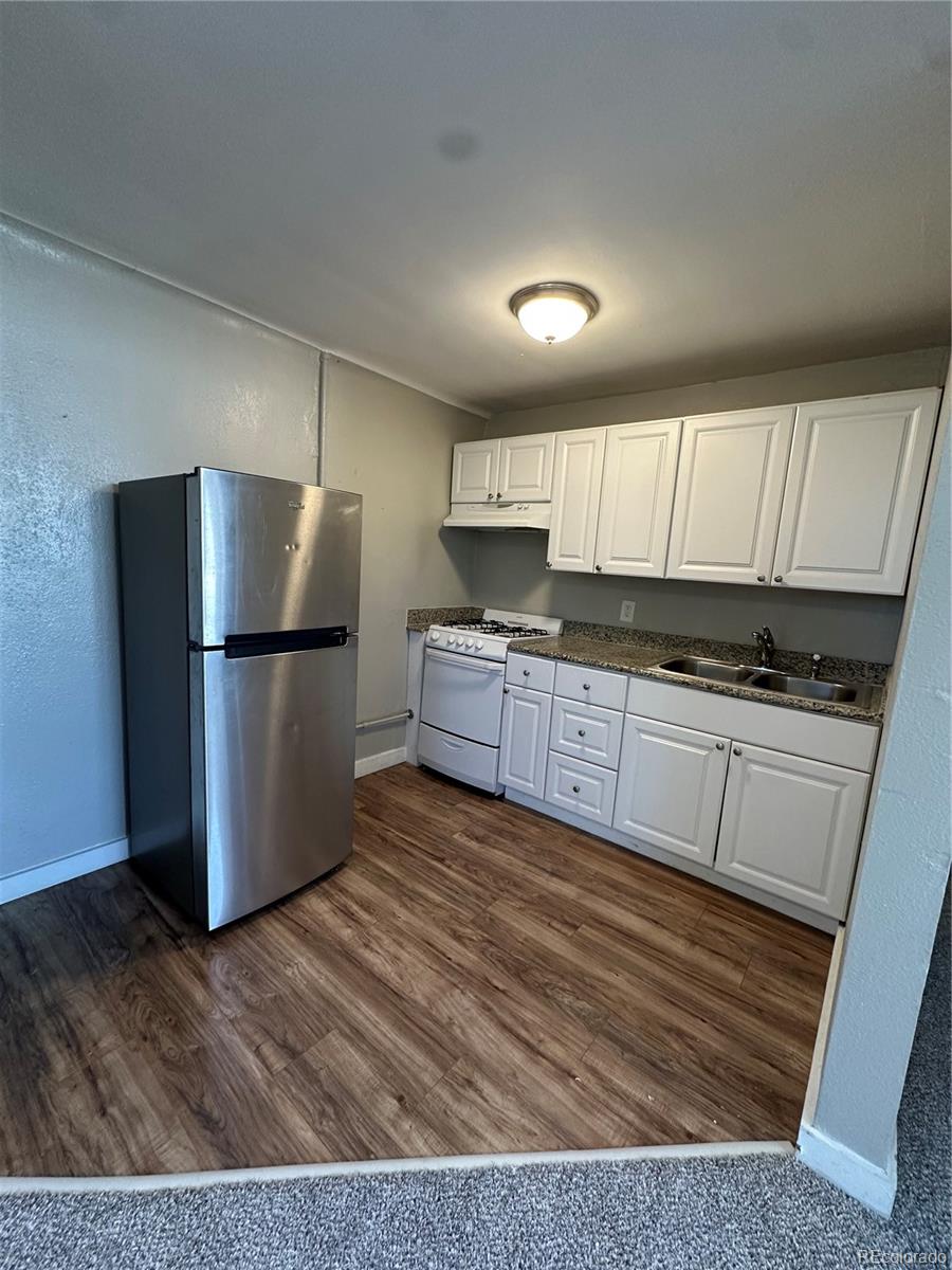 1400 South Clermont Street, Unit 7 Denver, CO 80222 - Photo 14 of 20 a kitchen with granite countertop a refrigerator and a stove top oven