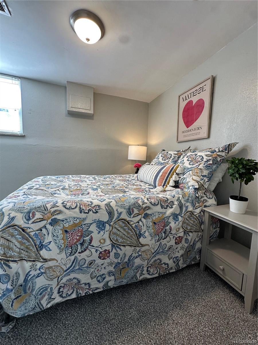 1400 South Clermont Street, Unit 7 Denver, CO 80222 - Photo 15 of 20 a bed sitting in a bedroom next to a lamp