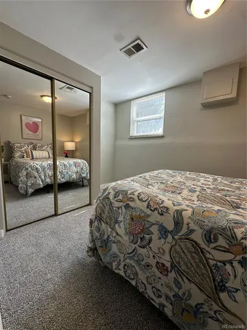 a bedroom with a bed and a lamp on dresser