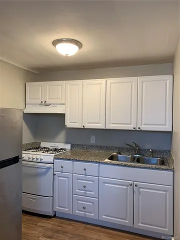a kitchen with granite countertop a stove and cabinets