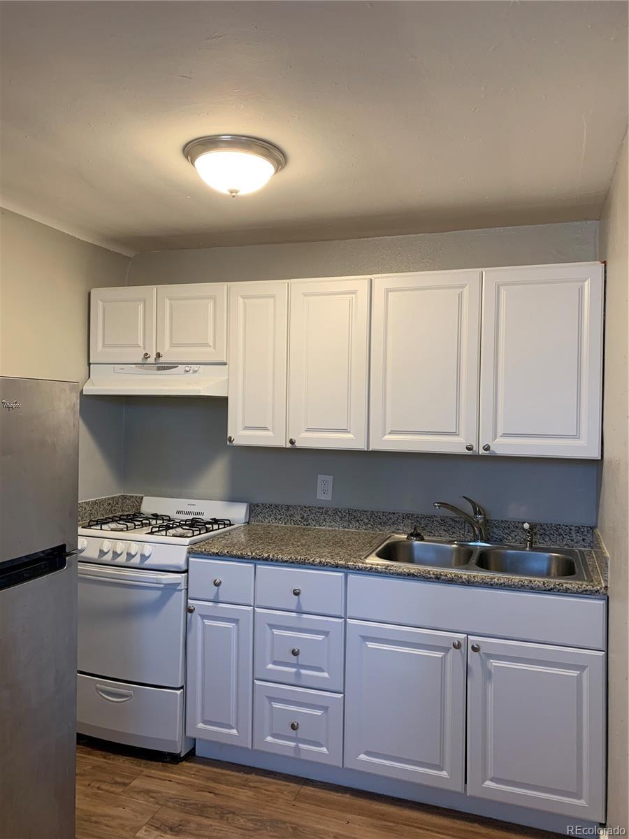 1400 South Clermont Street, Unit 7 Denver, CO 80222 - Photo 3 of 20 a kitchen with granite countertop a stove and cabinets