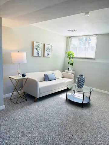 a living room with furniture and a potted plant