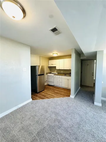 a view of a kitchen with refrigerator and a stove