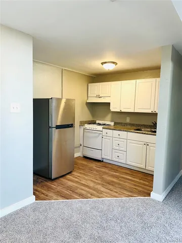 a kitchen with a refrigerator sink and cabinets