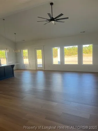 a view of an empty room with window and wooden floor