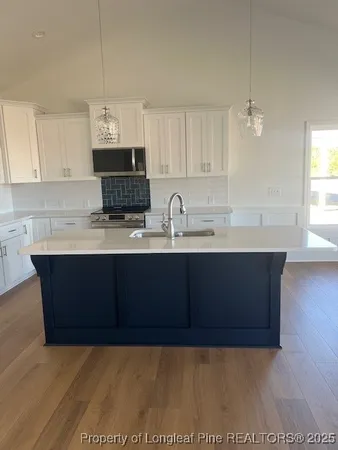 a kitchen with kitchen island granite countertop a sink wooden cabinets and a granite counter top