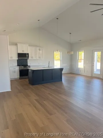 a large room with kitchen island and wooden floor