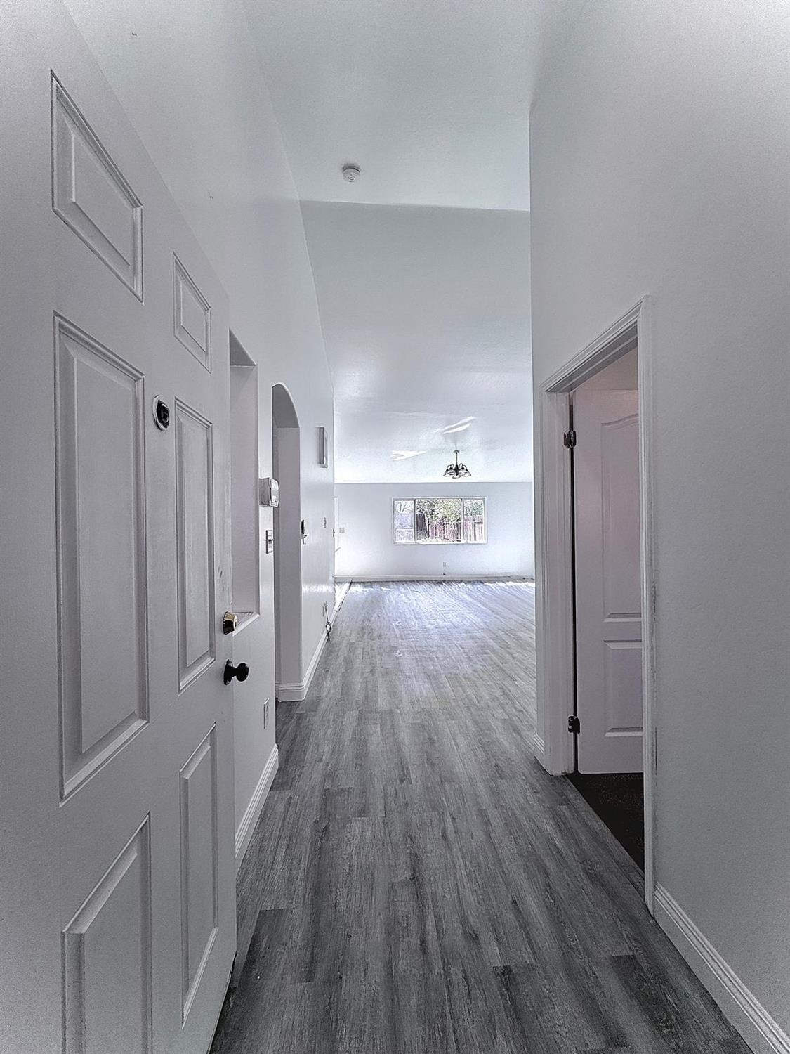 7111 Santana Sun Drive Bakersfield, CA 93313 - Photo 2 of 13 a view of a hallway with wooden floor and a cabinet