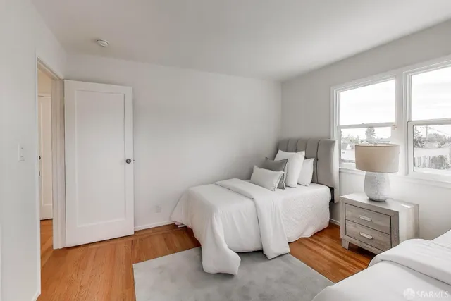 a bedroom with a bed and a large window