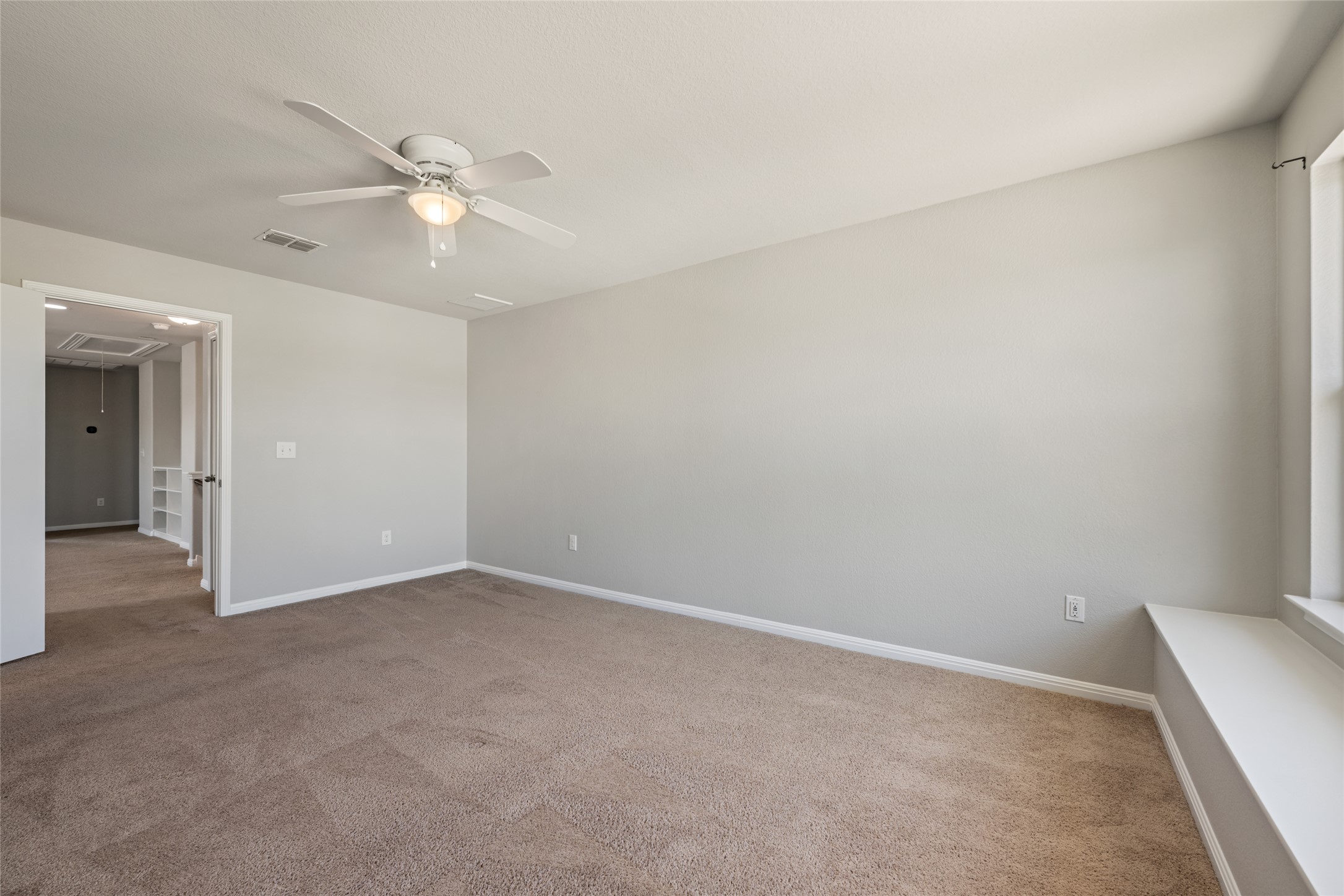 124 Guemal Road Buda, TX 78610 - Photo 30 of 40 A spacious room with soft carpet and a window bench awaits your personal touch.