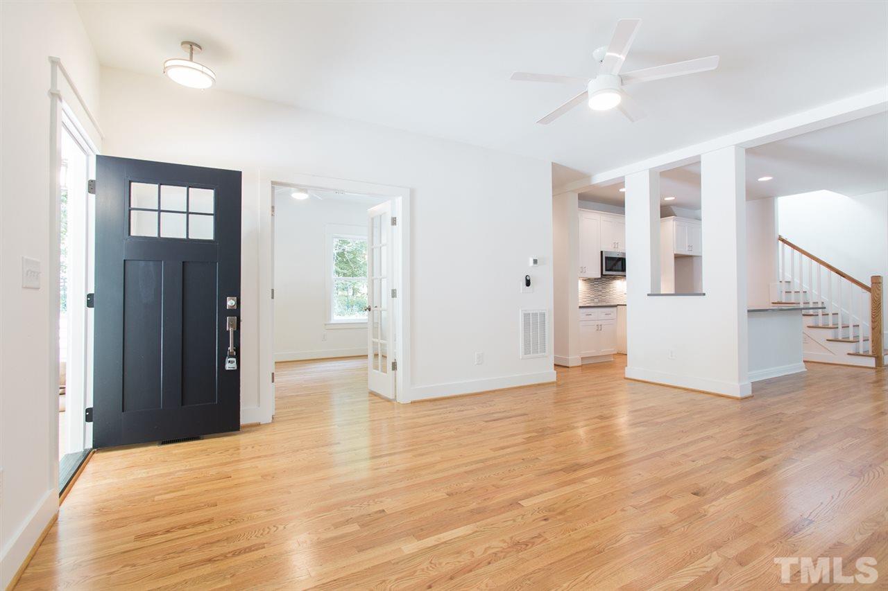 5316 Russell Road Durham, NC 27712 - Photo 4 of 25 a view of an empty room with wooden floor and a kitchen