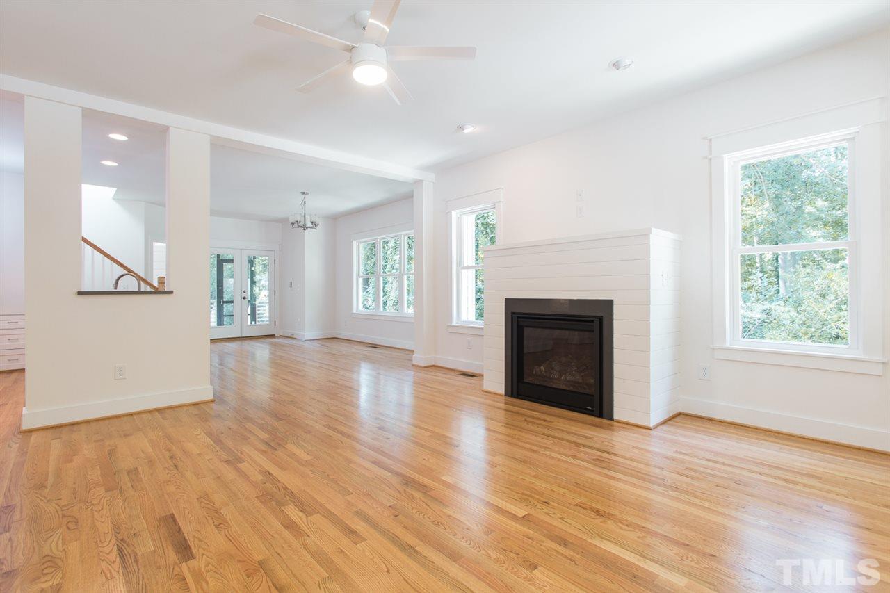 5316 Russell Road Durham, NC 27712 - Photo 5 of 25 an empty room with wooden floor a fireplace and windows