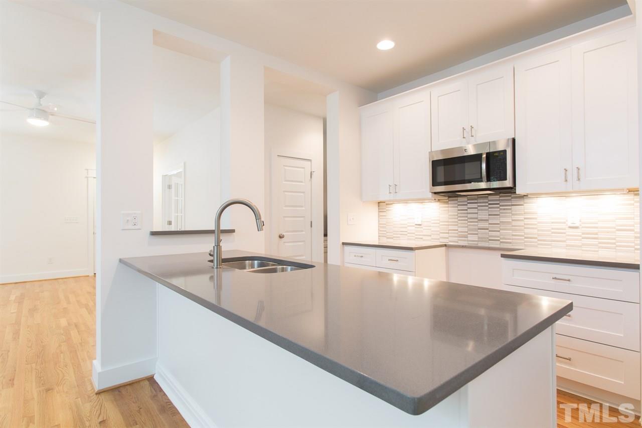 5316 Russell Road Durham, NC 27712 - Photo 8 of 25 a kitchen with kitchen island a sink and a stove with wooden floor