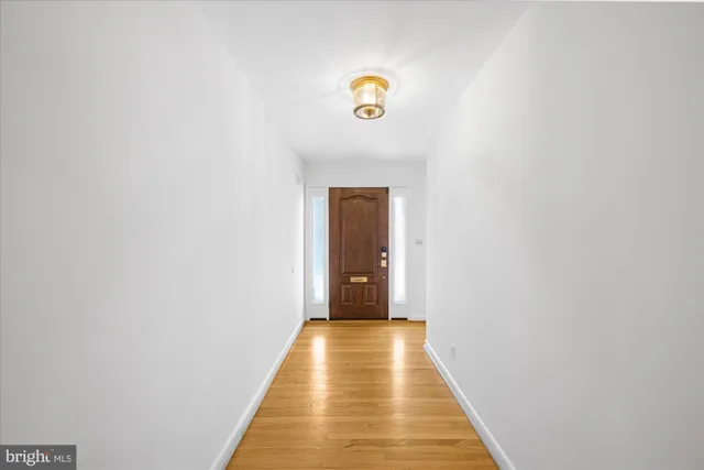 a view of empty room with wooden floor and fireplace