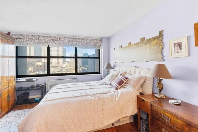 a bedroom with a bed and a large window