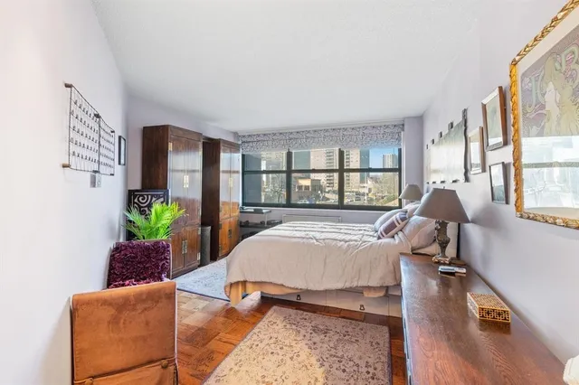 a living room with furniture floor to ceiling window and wooden floor
