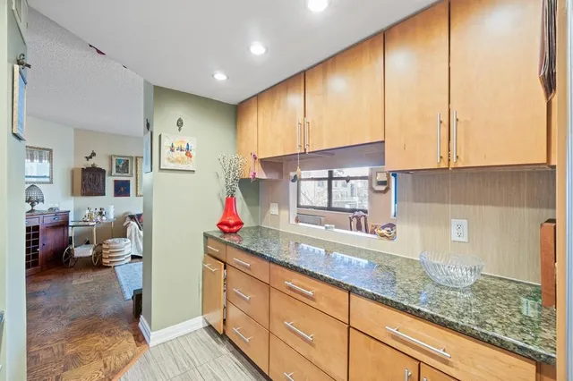 a kitchen with granite countertop a sink a stove and cabinets