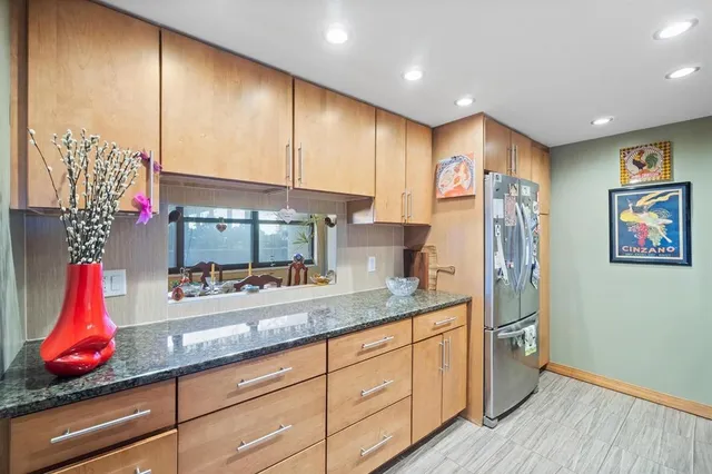 a kitchen with stainless steel appliances granite countertop a stove a sink and a refrigerator