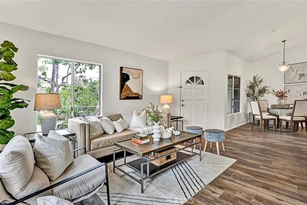 a living room with furniture a wooden floor and a large window