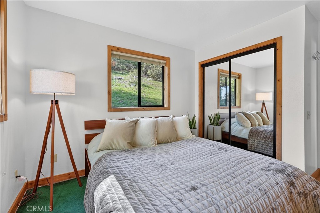 5851 Mt Bullion Ridge Road Mariposa, CA 95338 - Photo 20 of 58 a bedroom with a bed and a large mirror next to a window