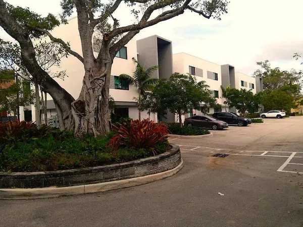 a view of a street with a building and trees in the background