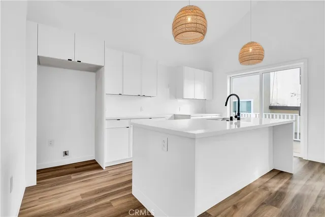 a kitchen with a sink cabinets and wooden floor
