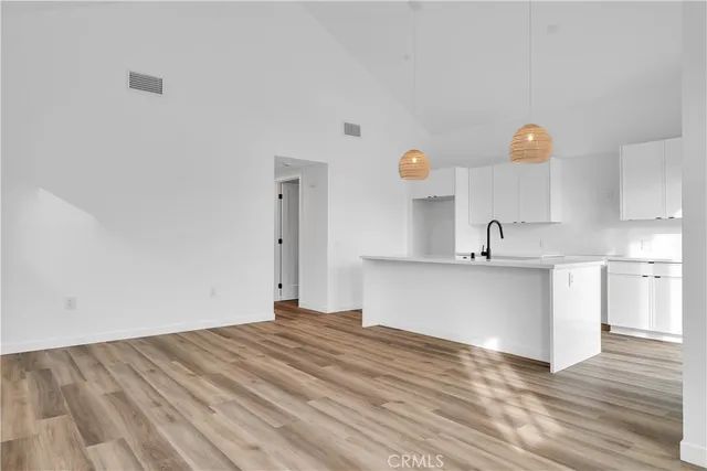 a view of a kitchen with wooden floor and a sink