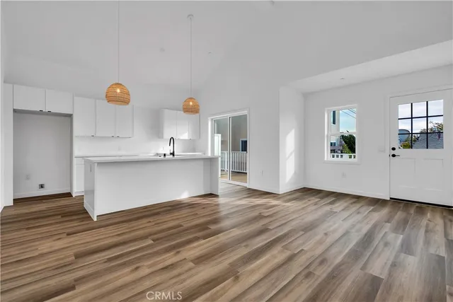 a view of a kitchen with wooden floor and windows